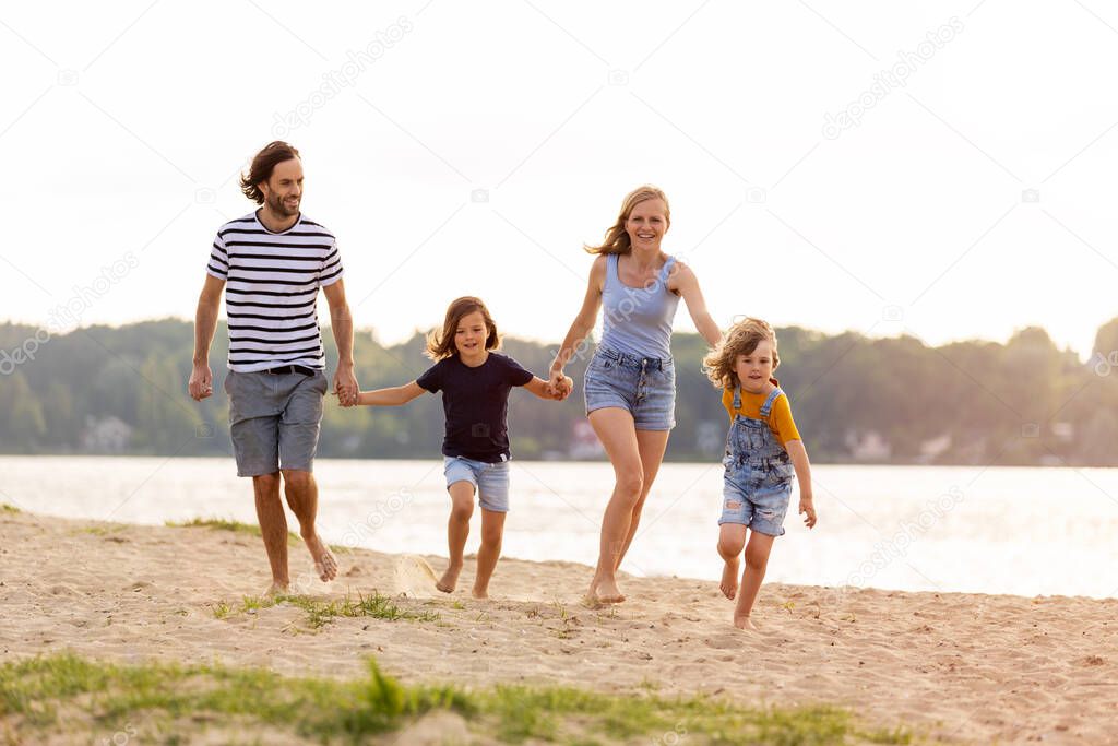 Shot of a family of four spending the day at the beach