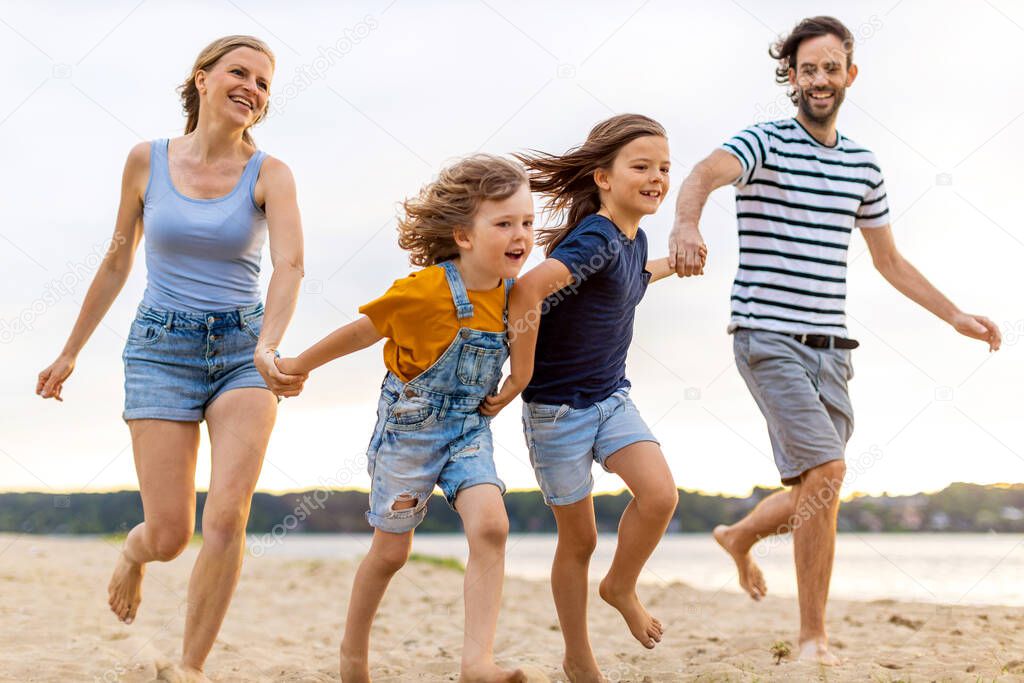 Shot of a family of four spending the day at the beach