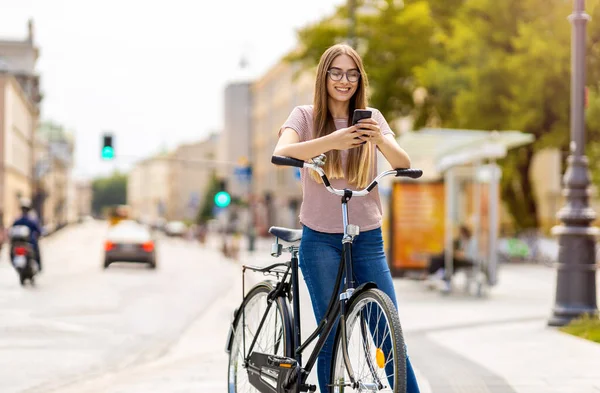 Ελκυστική Νεαρή Γυναίκα Χρησιμοποιώντας Smartphone Ενώ Έξω Ποδηλασία Μέσα Από — Φωτογραφία Αρχείου