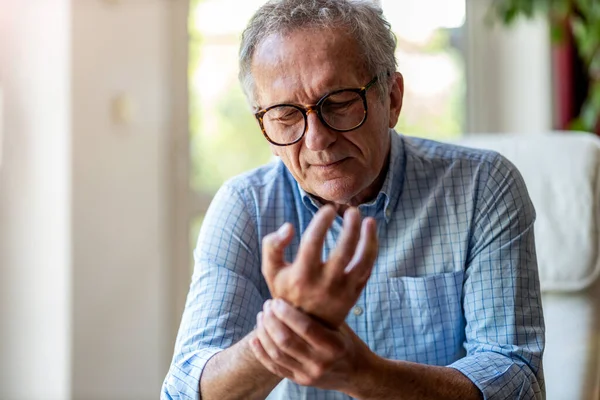 Senior Man Med Artrit Gnugga Händerna — Stockfoto