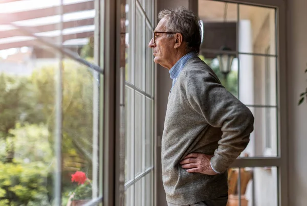 Hombre Mayor Mirando Por Ventana Casa — Foto de Stock