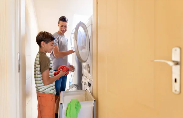 Two Boys Loading Washing Machine Together Home — Stock Photo, Image