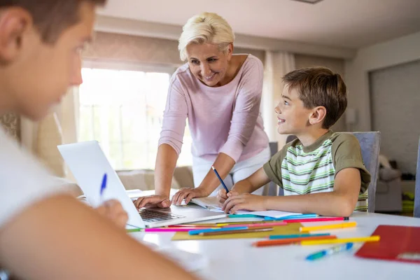 Mutter Hilft Ihren Kindern Bei Hausaufgaben Hause — Stockfoto
