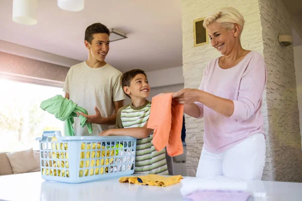 Μητέρα Και Γιοι Διαλογή Μέσω Πλυντηρίου Μαζί Στο Σπίτι — Φωτογραφία Αρχείου