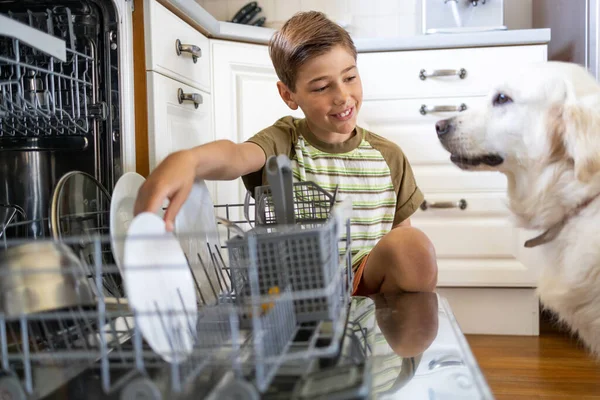 Маленький Хлопчик Заряджає Посудомийну Машину Вдома — стокове фото