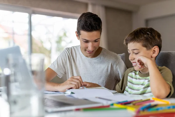 Хлопчик Підліток Допомагає Молодшому Братові Робити Домашнє Завдання Вдома — стокове фото
