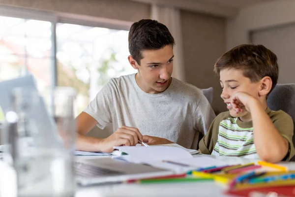 Teenager Junge Hilft Seinem Jüngeren Bruder Bei Hausaufgaben Hause — Stockfoto