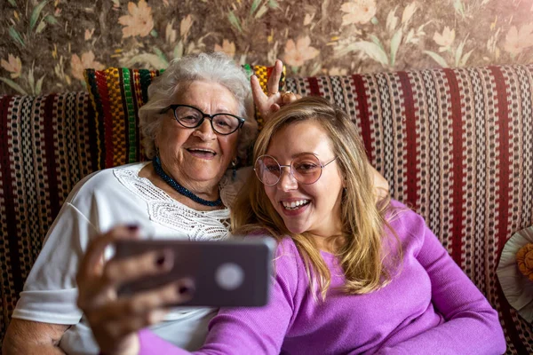 Senior Kvinna Och Hennes Vuxna Barnbarn Använder Smartphone Tillsammans — Stockfoto