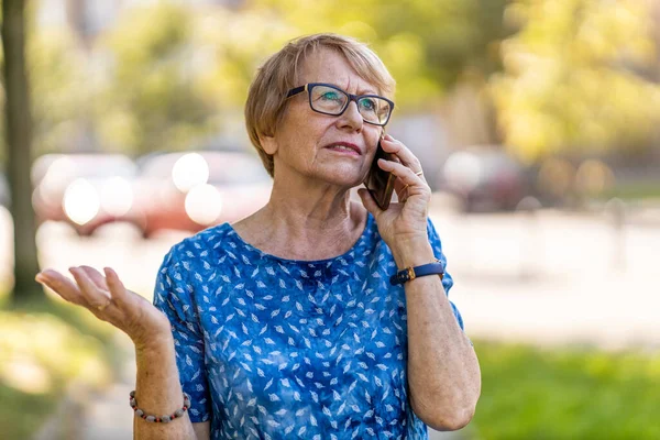 Zestresowana Starsza Kobieta Korzystająca Telefonu Komórkowego Zewnątrz — Zdjęcie stockowe