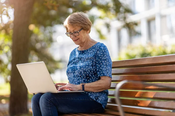 Femme Âgée Utilisant Ordinateur Portable Sur Banc Extérieur — Photo