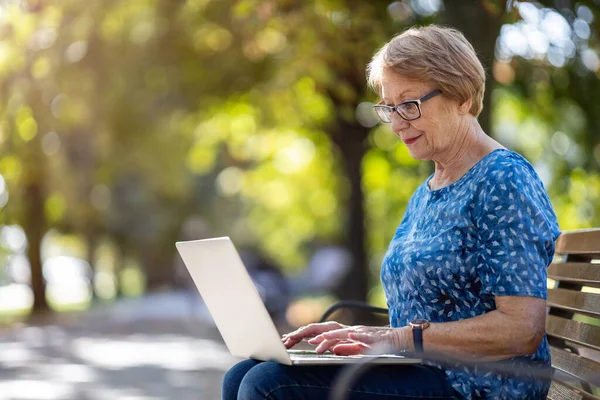 Femme Âgée Utilisant Ordinateur Portable Sur Banc Extérieur — Photo