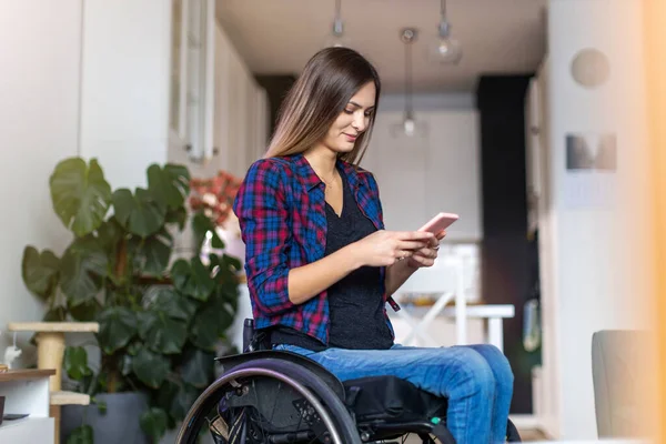 自宅のスマートフォンで車椅子の女性 — ストック写真