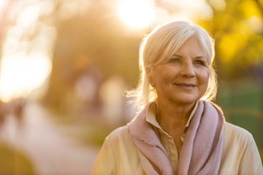 Sunset 'te sonbahar renklerinin tadını çıkaran son sınıf kadını.