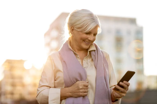 Старша Жінка Використовуючи Мобільний Телефон Свіжому Повітрі Під Час Заходу — стокове фото