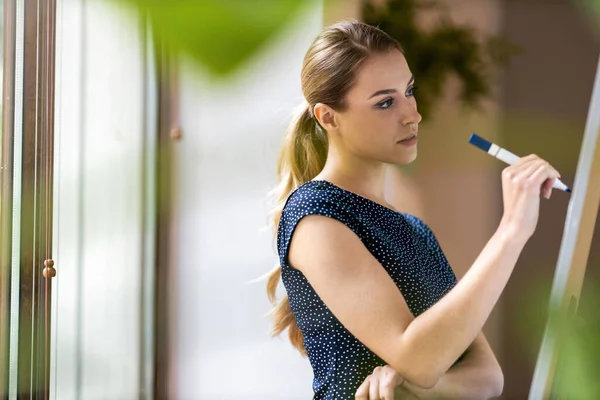 Genç Kadını Kalemini Ofisinde Beyaz Tahtaya Yazıyor — Stok fotoğraf