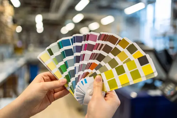 Woman hands with color samples at printing press