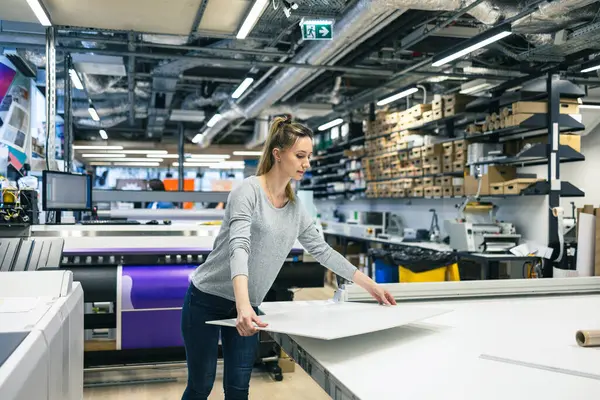 在印刷厂工作的妇女 免版税图库照片