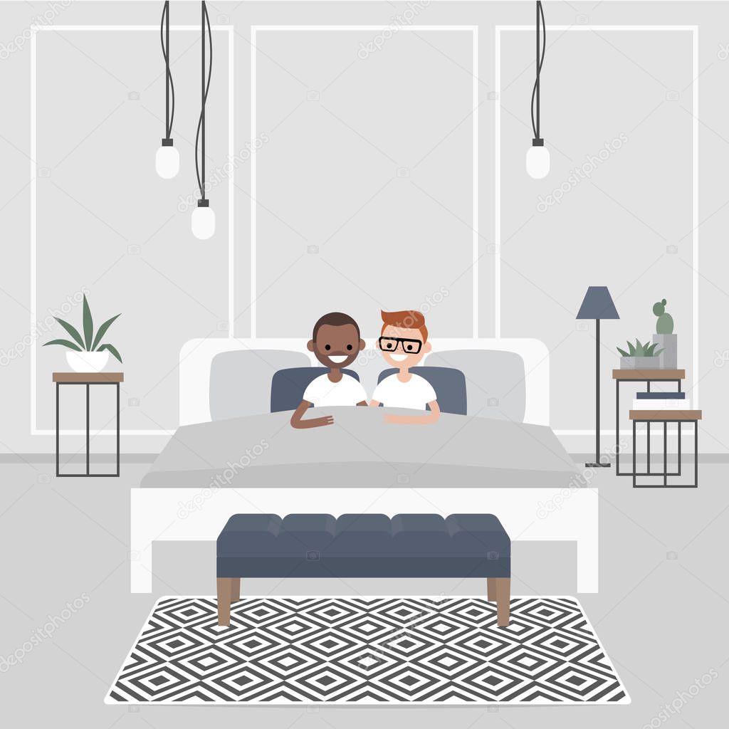 Modern bedroom interior. Couple of young adults lying in the double bed. Homosexual relationships. Gay partners. LGBTQ. Scandinavian design.