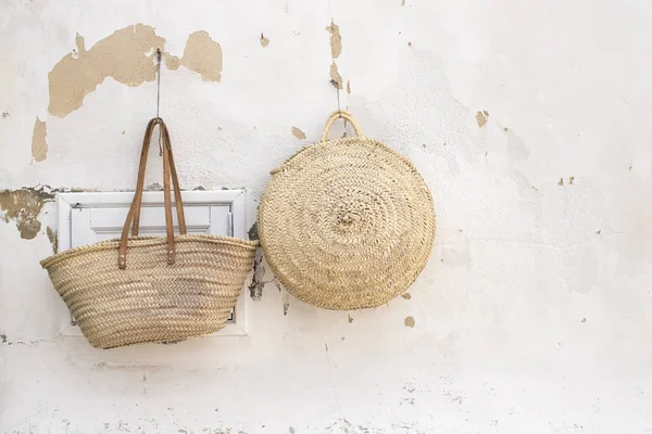 Bir duvarda asılı iki hasır çanta