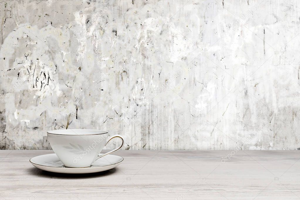 Vintage teacup on a white wooden table, textured wall