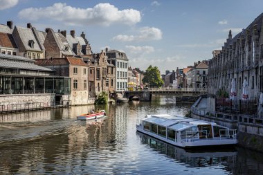 Gent, Belçika - 13 Haziran 2017: Turistler eski şehirde nehirüzerinde tekne gezisinin keyfini çıkarıyor
