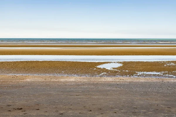 Oostduinkerke, Bélgica - 19 de junio de 2019: Paisaje marino minimalista en capas con tintes azules, verdes y anaranjados — Foto de Stock