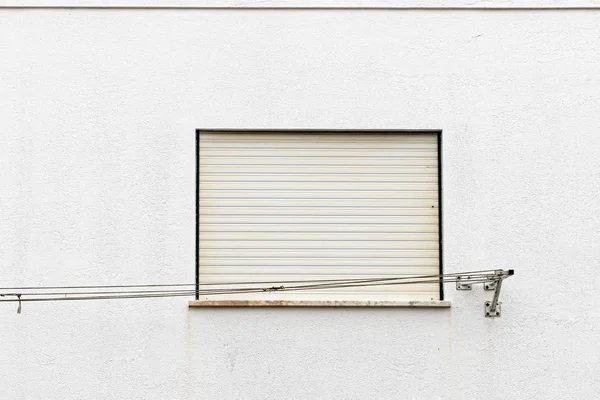 Nazare, Πορτογαλία-17 Ιουλίου 2019: διαβρωμένη κενή γραμμή πλύσης μπροστά από έναν λευκό τοίχο και παράθυρο — Φωτογραφία Αρχείου