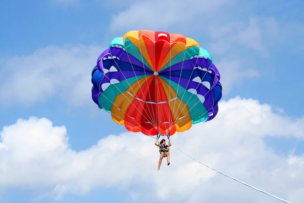 Klein blij meisje op kleurrijke parasail in de blauwe hemel — Stockfoto