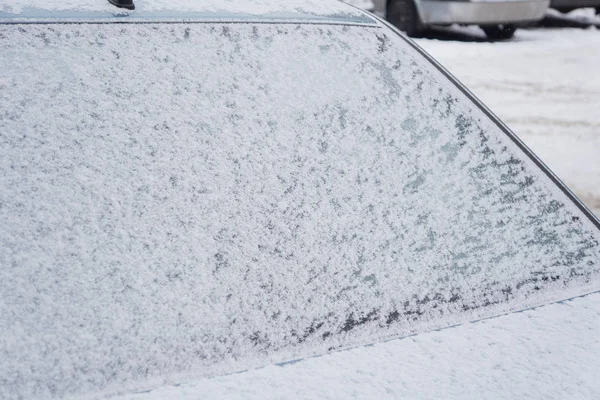 Fryst bakrutan på bilen, täckt med is och snö på en vinterdag. — Stockfoto