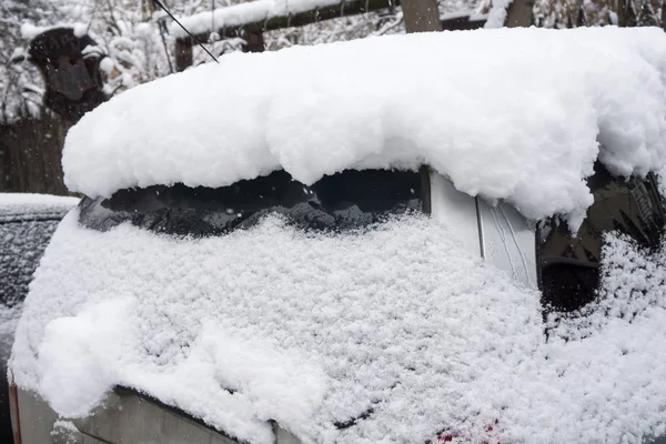 El coche, cubierto de gruesa capa de nieve. Consecuencias negativas de fuertes nevadas. vehículos aparcados — Foto de Stock
