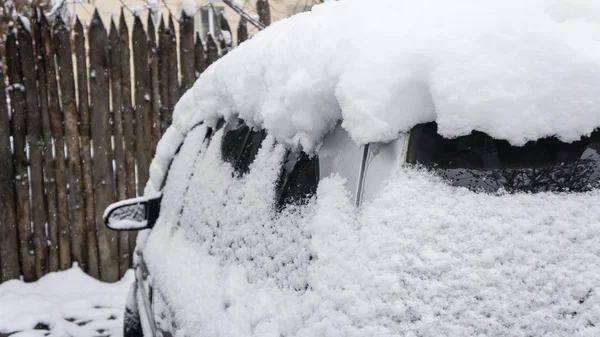 Samochód, pokryte grubą warstwą śniegu. Ujemną konsekwencją obfite opady śniegu. zaparkowane samochody — Zdjęcie stockowe