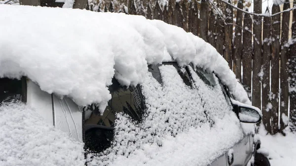 El coche, cubierto de gruesa capa de nieve. Consecuencias negativas de fuertes nevadas. vehículos aparcados — Foto de Stock