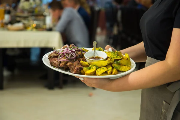 Kelnerka Prowadzi Płytkę Ziemniakami Kebaby Zaprasza Stole Bankietowym Usługi Restauracyjne — Zdjęcie stockowe