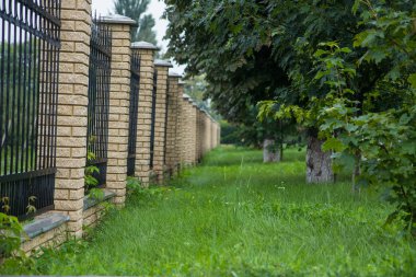 Çevrede belgili tanımlık ev tuğla ayağı ile modern bir metal çit