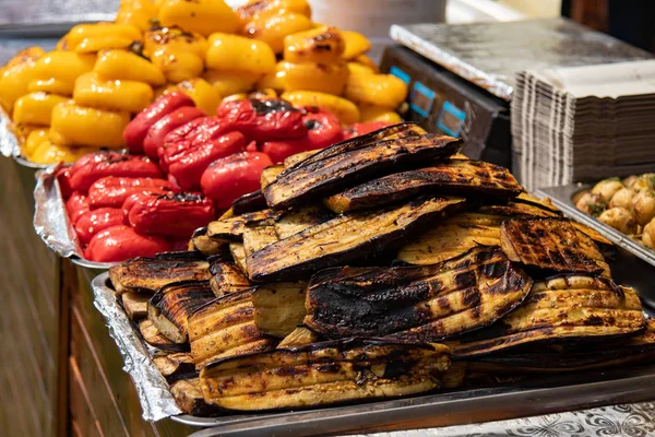 Grillezett padlizsán. piros és sárga színű paprika a grill van a pultra. Utcai élelmiszer-fesztivál — Stock Fotó