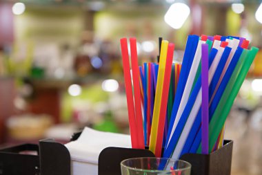 Bar tezgahında renkli pipetleri kapatın. Bulanık parlak arkaplan.