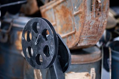 Eski paslı kutuların arka planına karşı bir film makarası..