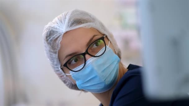 Uma Jovem Médica Com Óculos Olha Para Monitor Durante Operação — Vídeo de Stock