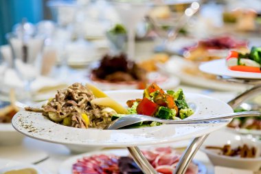 Restorandaki festival masasında Sezar salatası, sebzeler.