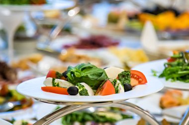 Restorandaki şenlik masasında Caprese salatası, yemek, sebze