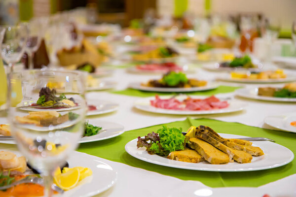 Игристые стеклянные стенды на длинном столе, приготовленном к свадебному ужину.