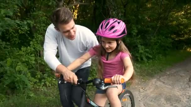 Μεγαλύτερος Αδερφός Μαθαίνει Στη Μικρότερη Αδερφή Κάνει Ποδήλατο Στο Πάρκο — Αρχείο Βίντεο