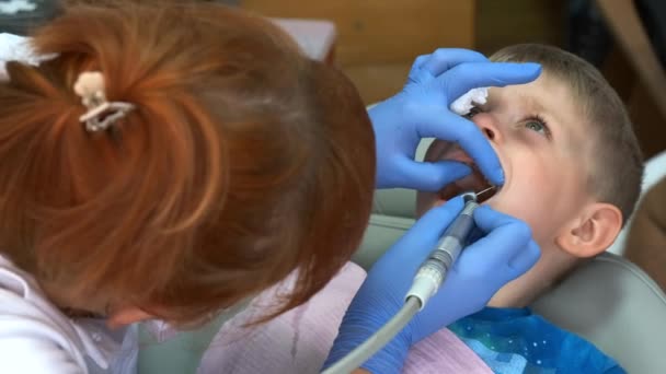 Menino Numa Cadeira Consultório Dentário Uma Dentista Feminina Luvas Proteção — Vídeo de Stock