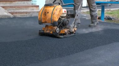 Yol vibroplakalı asfalt sıkıştırması. Yerleşim yerlerinin yakınındaki kaldırımlara kendi ellerinizle çarpıyorsunuz..