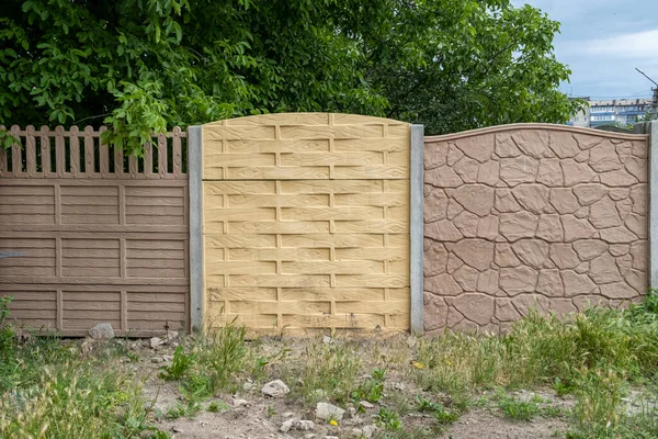 花园绿叶的背景下，篱笆上的多彩的混凝土墙板. — 图库照片