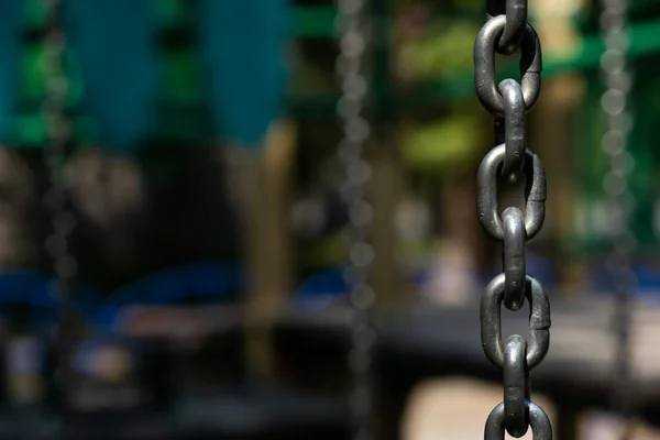 iron chain from a swing on a blurred background.