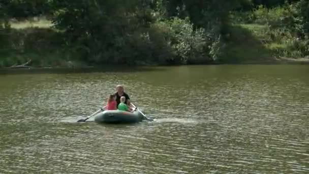 父の娘と息子はゴムボートで川に浮かんでいる 自然の中で家族の休暇の概念 — ストック動画