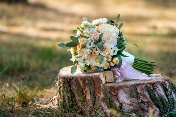 Beautiful bouquet of roses in pink tones lies on a tree stump. Wedding decor — Stock Photo, Image