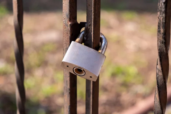 Gris, viejo, candado oxidado pesa sobre una cerca vieja — Foto de Stock