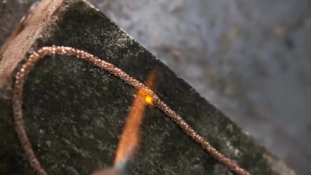 用珠宝工具和气体燃烧器在耐火砖上加工装饰金金属链件 — 图库视频影像